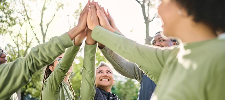 High five, nature et mains humaines lors d'un team building à l'occasion d'une retraite de bien-être avec la communauté et le soutien. Volontaire, bonheur et sourire d'un groupe de soutien enthousiaste à l'idée de collaborer, de faire confiance et d'être solidaire.