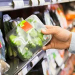 Hand takes product from supermarket shelf